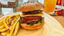 Una hamburguesa vegana con papas fritas y cerveza.